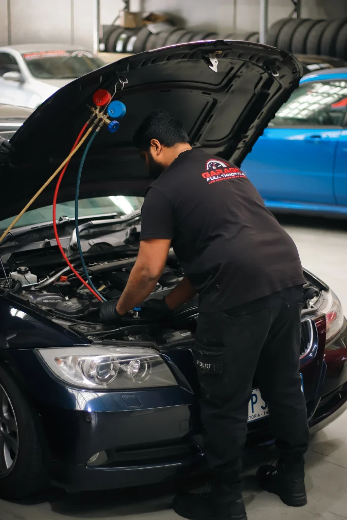 Garage Full Throttle Mechanic doing Air conditioning service