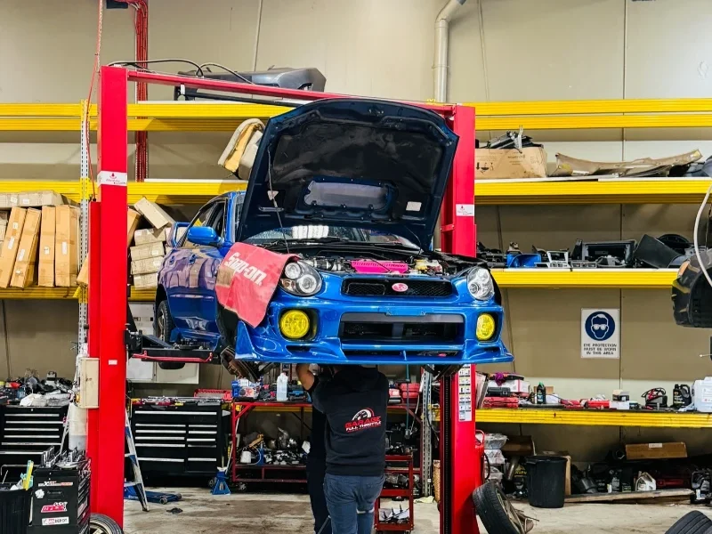 Subaru WRX on hoist during pre-roadworthy inspection at Garage Full Throttle Craigieburn showing engine and undercarriage check